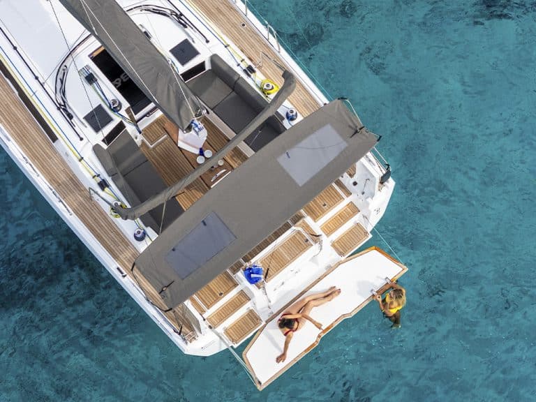 Estela — Dufour 44 from above, teak deck and swim platform in turquoise water